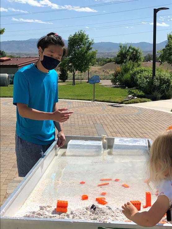 watershed team member helping little girl in exhibit