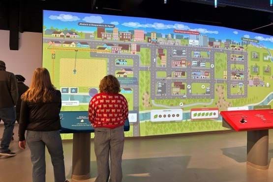 Two women interact with Sustainable Boise exhibit